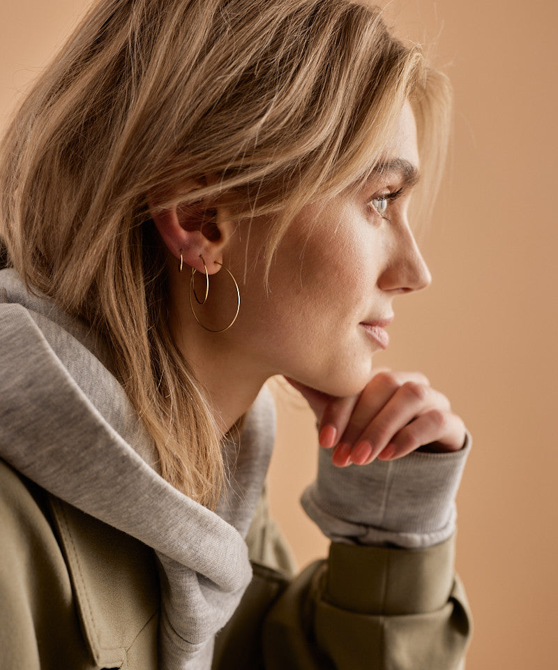 Model Wearing Pure Medical Grade Golden Titanium Ear Rings in the 35mm, 25mm , and 12mm size