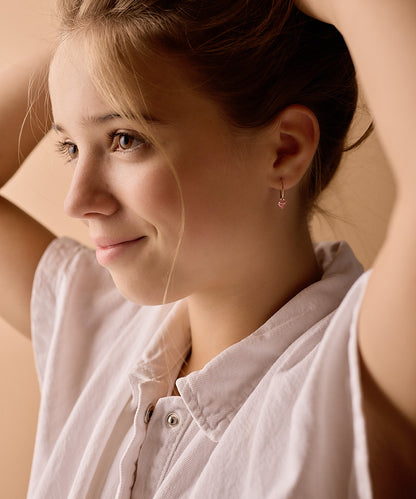 Model Wearing Golden Titanium Bicone Pendant 14mm Ear Rings in Light Rose